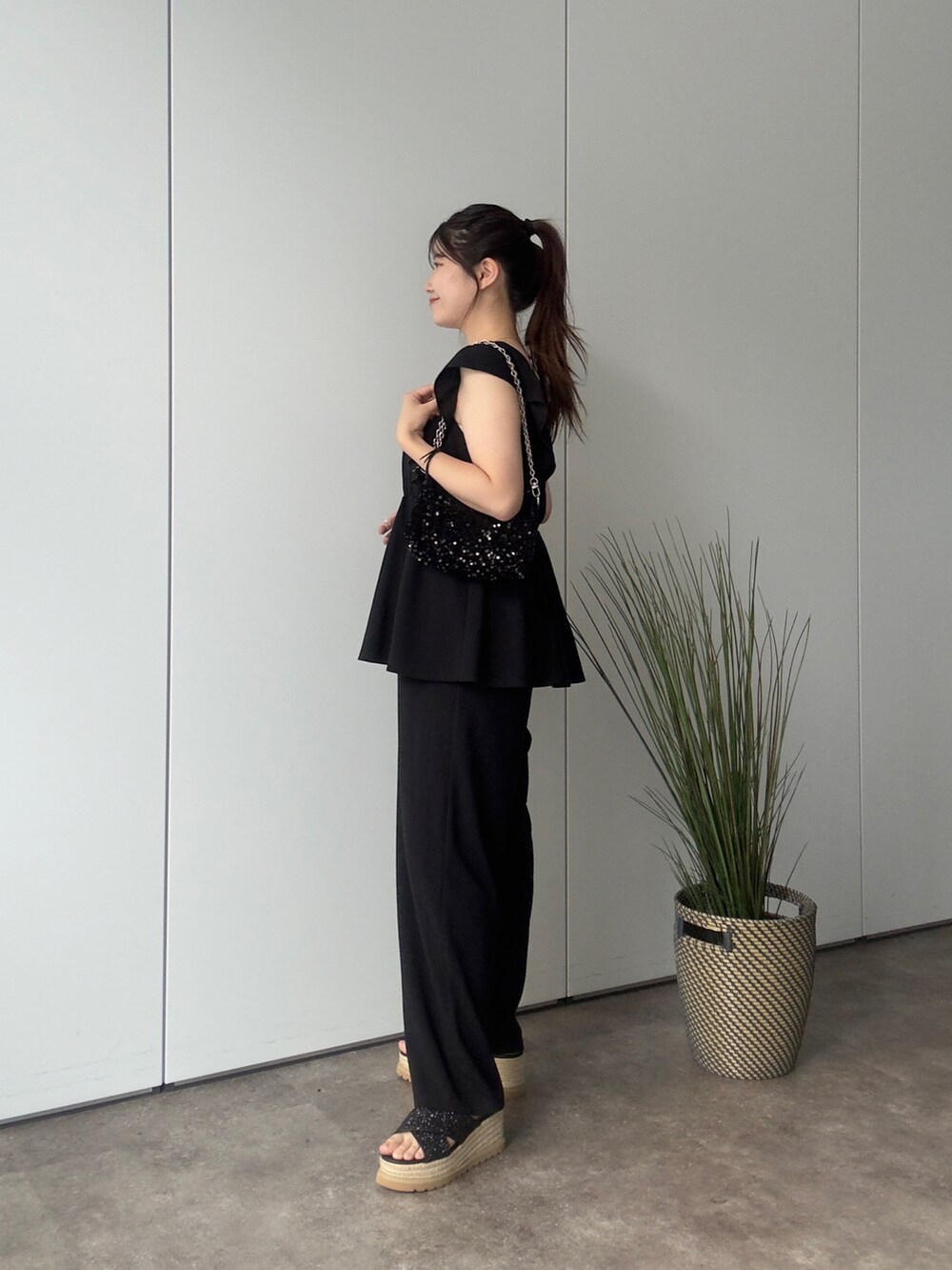 ブラック系のショルダーバッグ、ブラック系のサンダル、ブラック系のつなぎ/オールインワンを着用したレディースの夏コーディネートの2枚目の写真