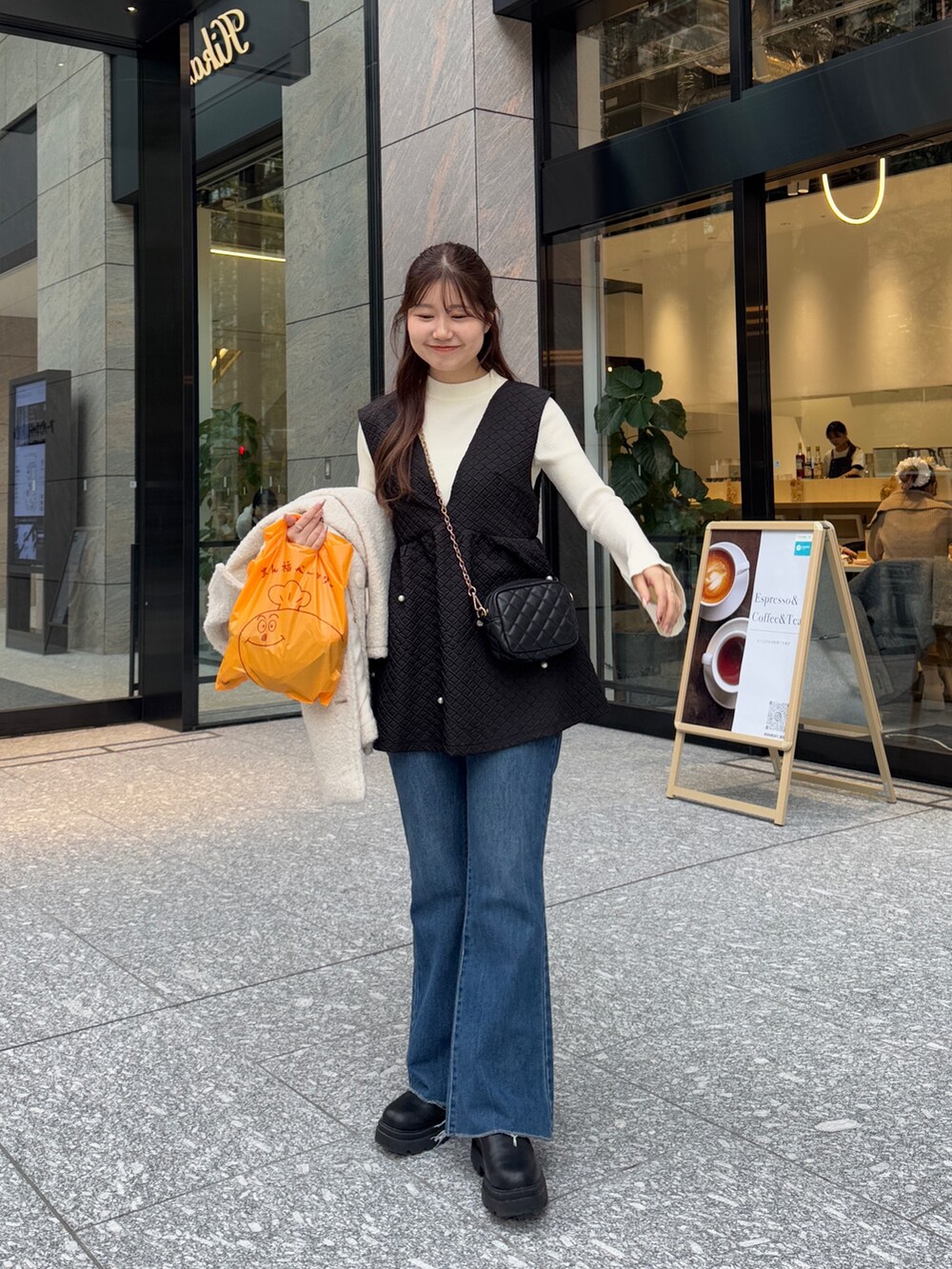 ホワイト系のニット/セーター、ブラック系のベスト、ブラック系のショルダーバッグを着用したレディースの冬コーディネートの3枚目の写真