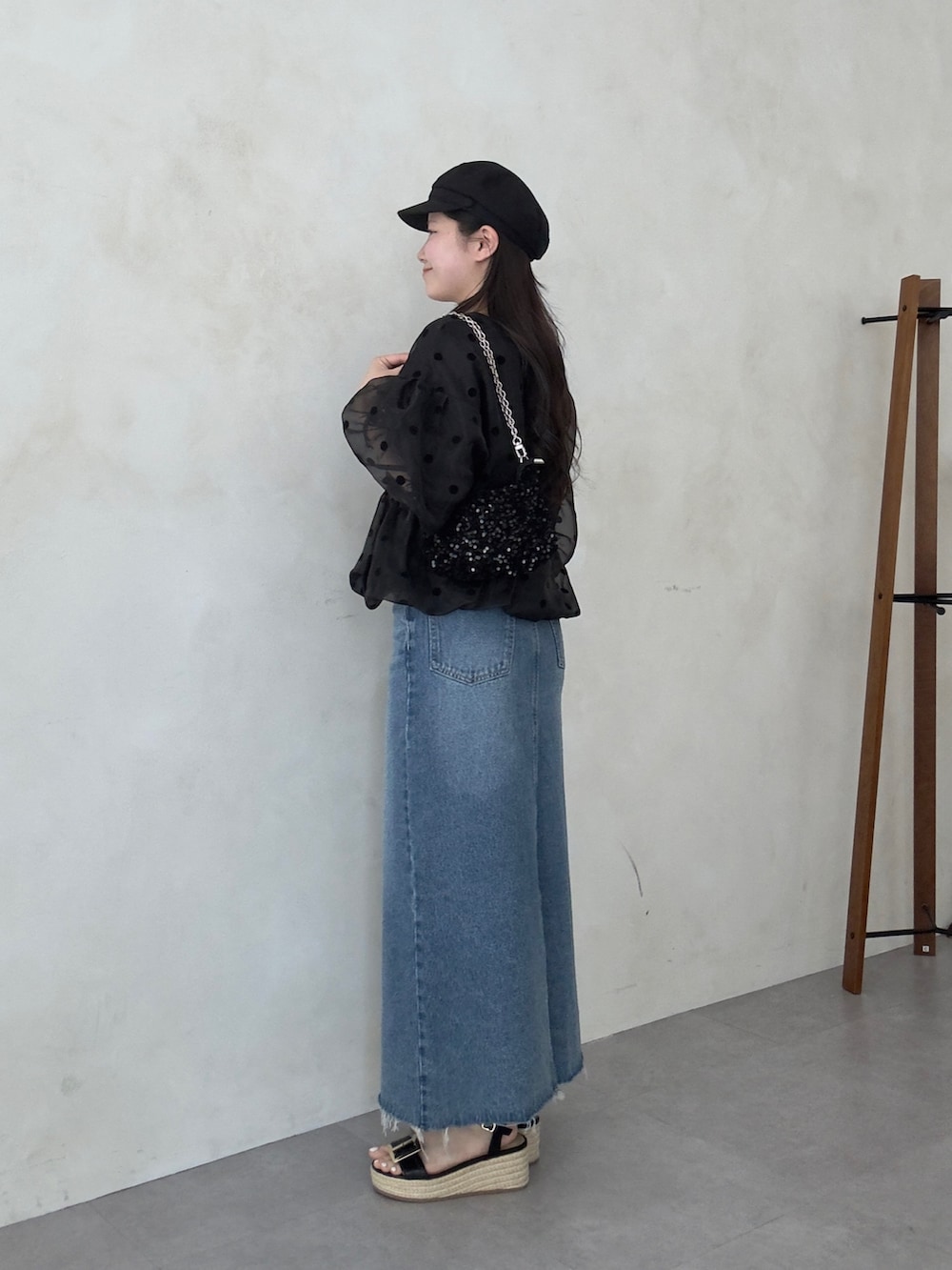 ブラック系のシャツ/ブラウス、ブルー系のスカート、ブラック系のサンダルを着用したレディースの春コーディネートの2枚目の写真