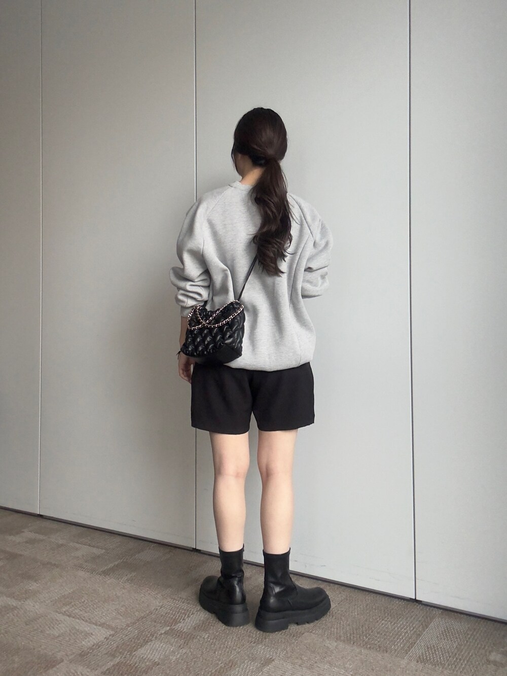 グレー系のスウェット、ブラック系のショルダーバッグ、ブラック系のその他パンツを着用したレディースの秋コーディネートの3枚目の写真