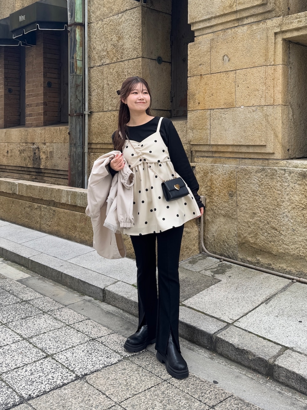 ブラック系のTシャツ/カットソー、ブラック系のショルダーバッグ、ホワイト系のキャミソールを着用したレディースの冬コーディネートの4枚目の写真