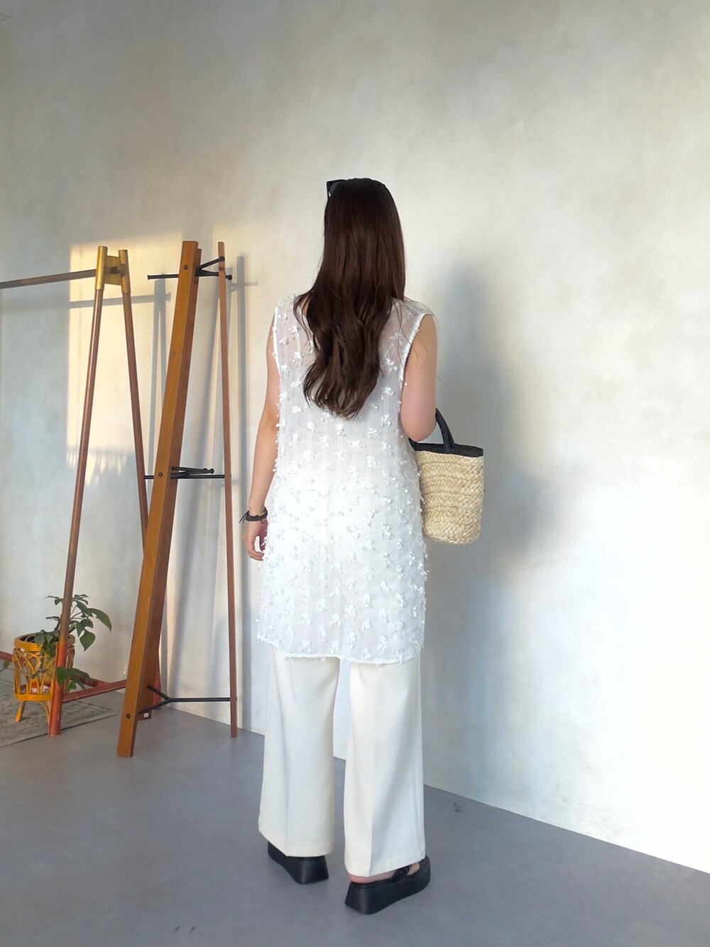 ホワイト系のその他パンツ、ブラック系のかごバッグ、ブラック系のサンダルを着用したレディースの夏コーディネートの4枚目の写真