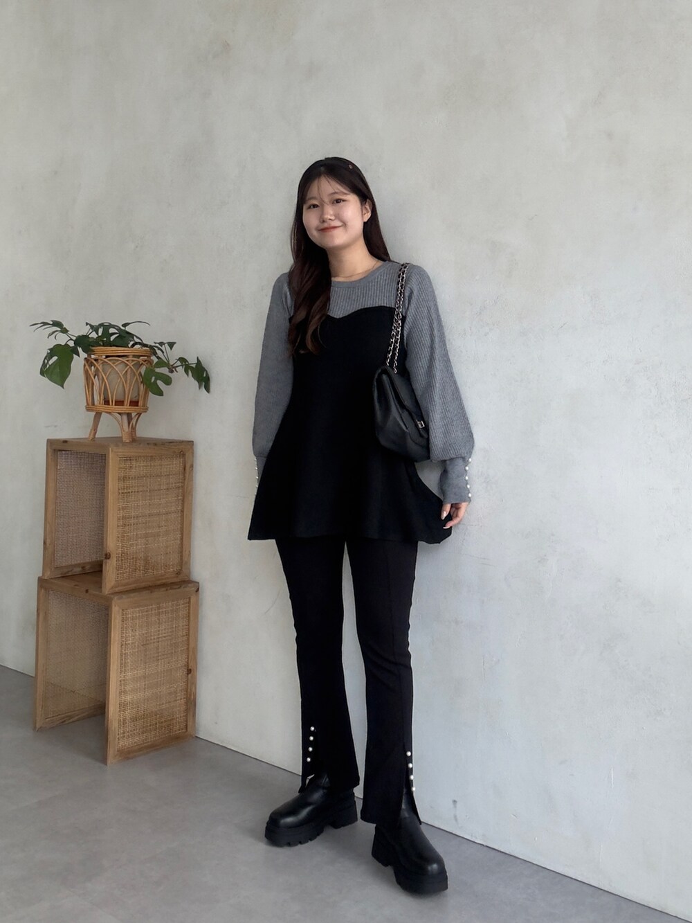 ブラック系のその他パンツ、ブラック系のブーツ、グレー系のニット/セーターを着用したレディースの秋コーディネートの2枚目の写真