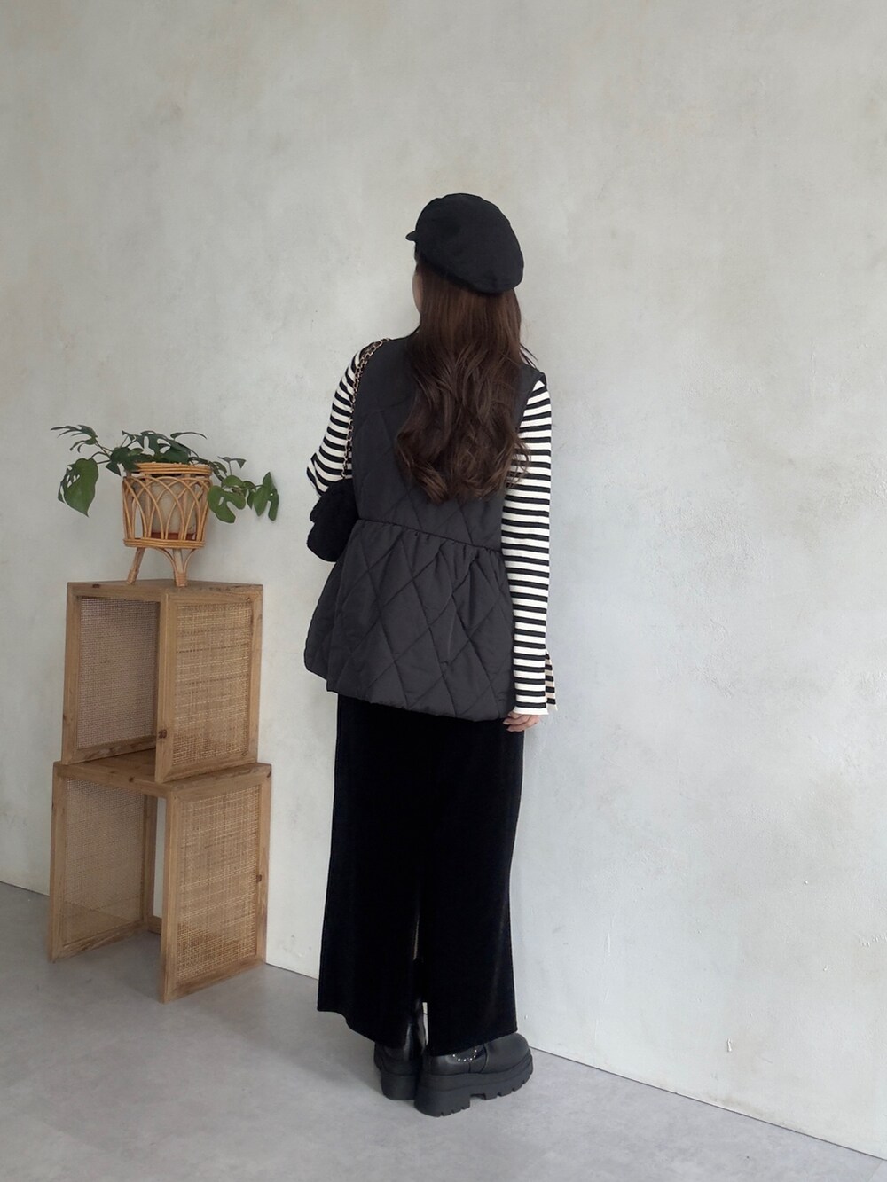 ブラック系のショルダーバッグ、ブラック系のベスト、ブラック系のスカートを着用したレディースの秋コーディネートの3枚目の写真