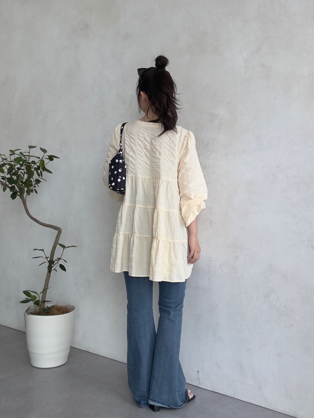 ブルー系のデニムパンツ、ブラック系のサンダル、ベージュ系のシャツ/ブラウスを着用したレディースの春コーディネートの3枚目の写真