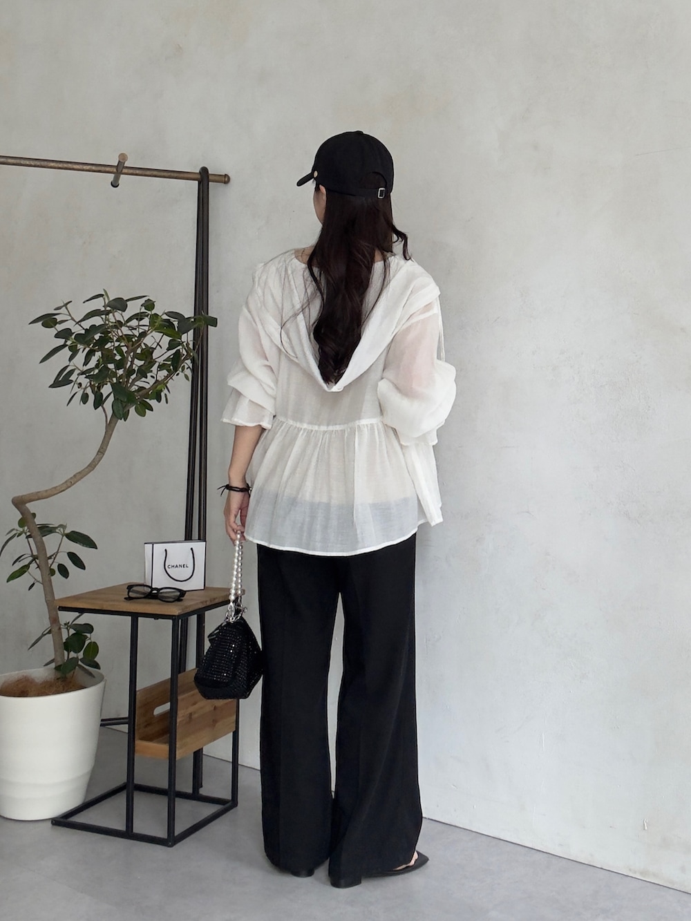 ホワイト系のシャツ/ブラウス、ブラック系のスラックス、ブラック系のサンダルを着用したレディースの夏コーディネートの3枚目の写真