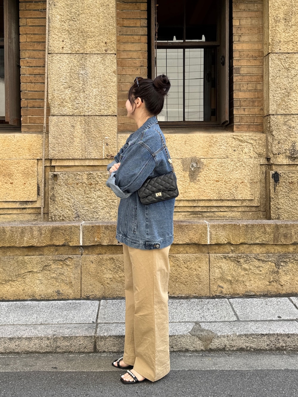 ブラック系のTシャツ/カットソー、ベージュ系のチノパンツ、ブラック系のサンダルを着用したレディースの春コーディネートの2枚目の写真