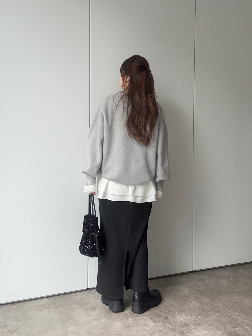 グレー系のTシャツ/カットソー、ホワイト系のTシャツ/カットソー、ブラック系のスカートを着用したレディースの冬コーディネートの3枚目の写真