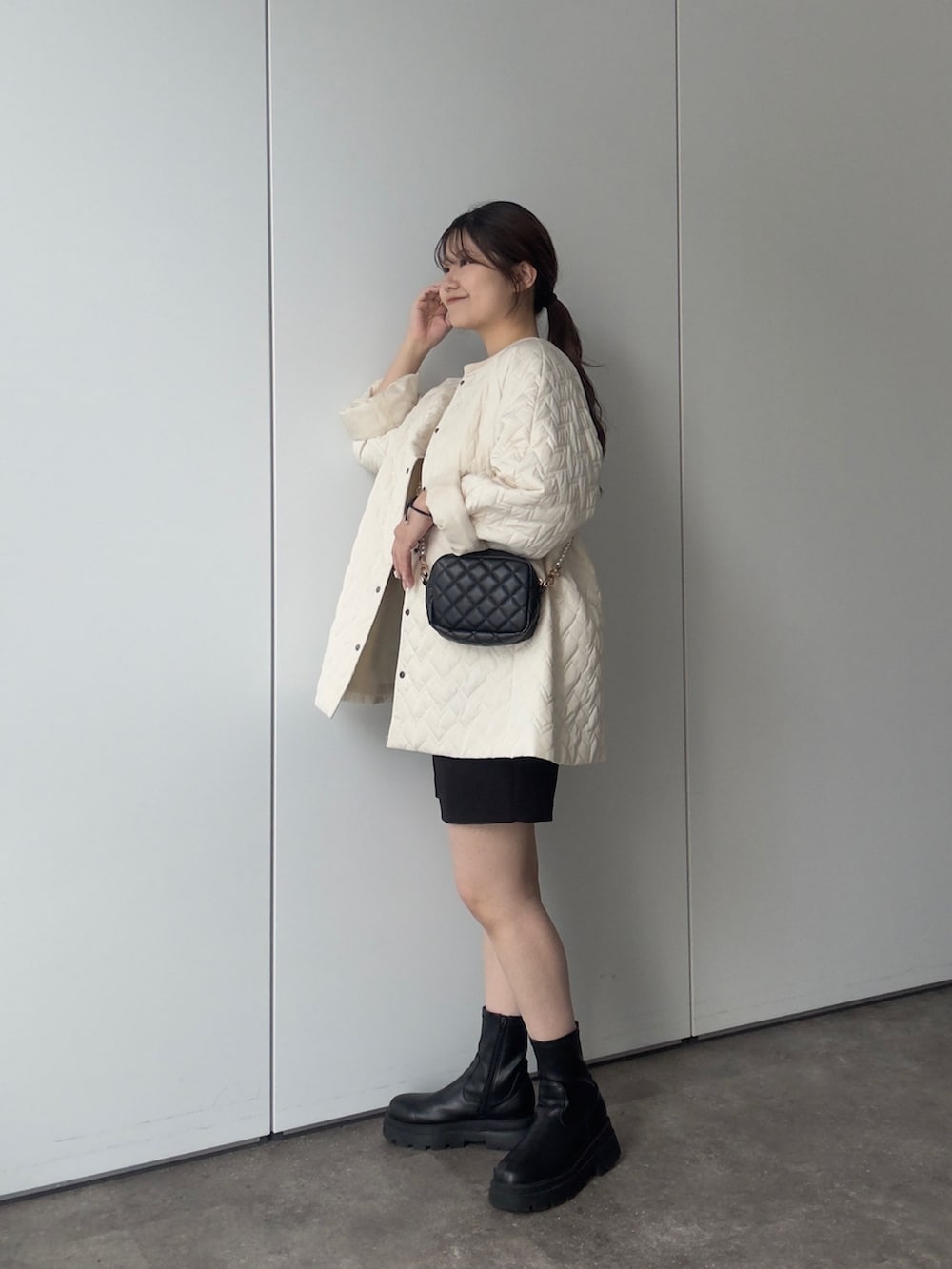 ホワイト系のブルゾン、ホワイト系のスウェット、ブラック系のショルダーバッグを着用したレディースの秋コーディネートの2枚目の写真