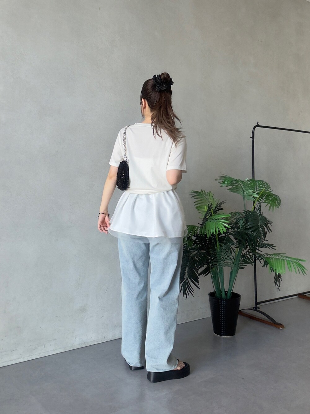 ホワイト系のTシャツ/カットソー、ブラック系のショルダーバッグ、ブルー系のデニムパンツを着用したレディースの夏コーディネートの3枚目の写真