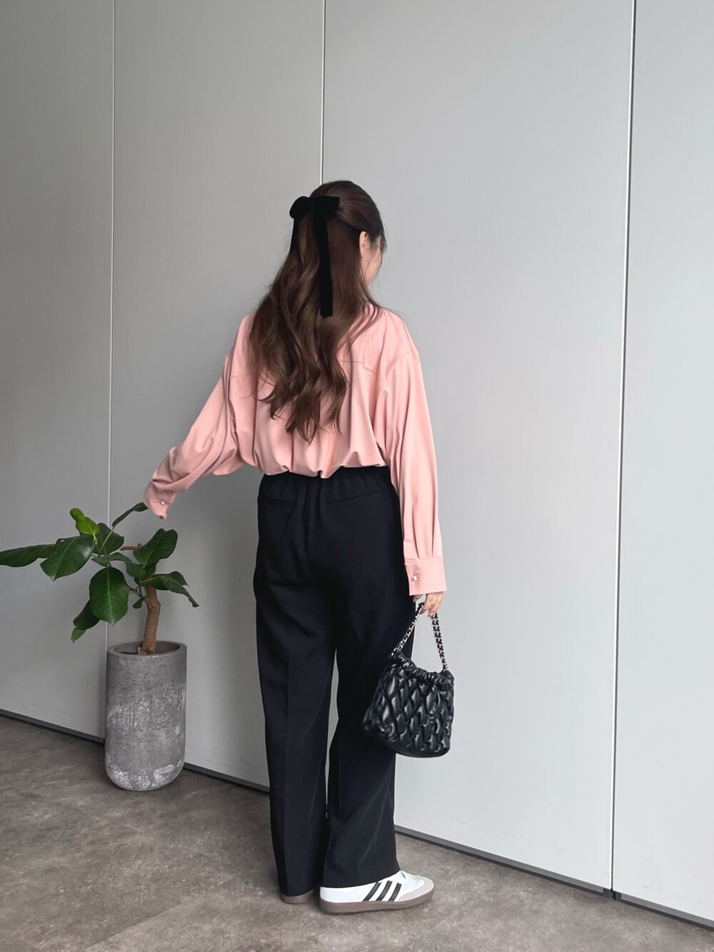 ブラック系のショルダーバッグ、ブラック系のスラックス、ホワイト系のスニーカーを着用したレディースの春コーディネートの3枚目の写真