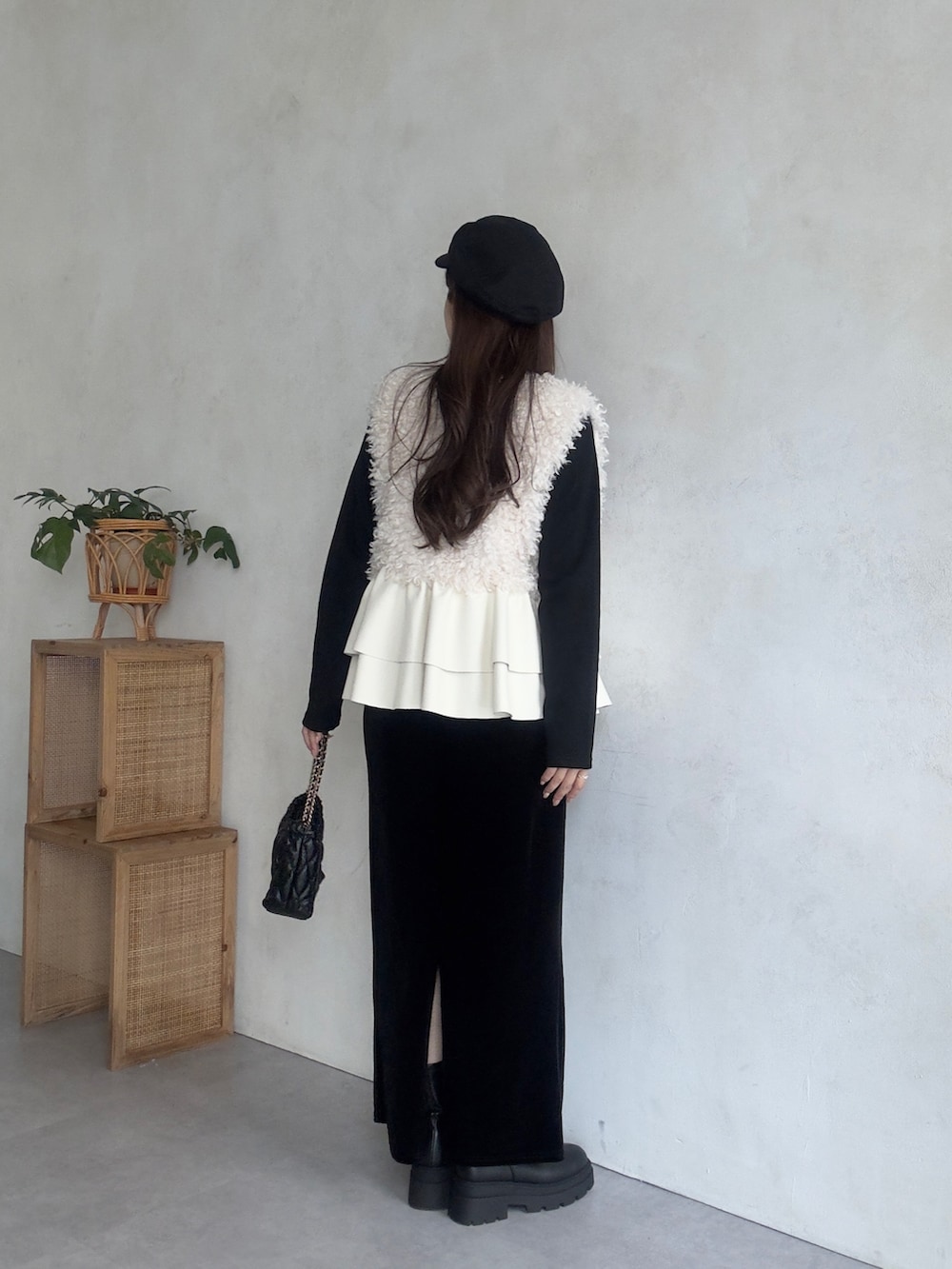 ホワイト系のベスト、ブラック系のスカート、ブラック系のブーツを着用したレディースの秋コーディネートの3枚目の写真