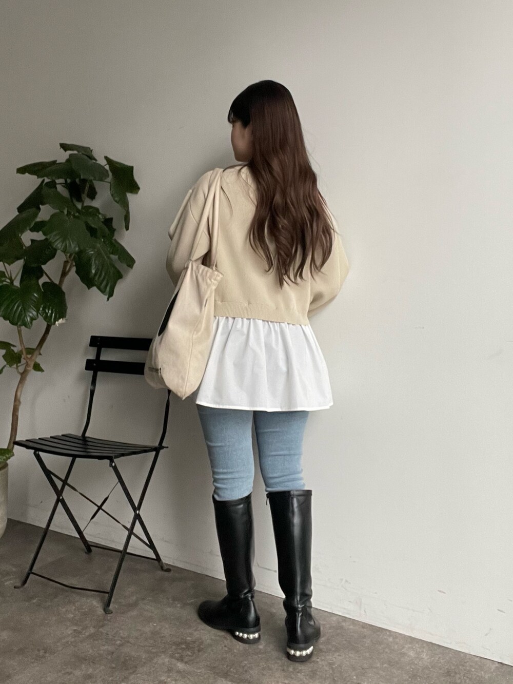 ホワイト系のカーディガン/ボレロ、ブルー系のデニムパンツ、ブラック系のブーツを着用したレディースの冬コーディネートの3枚目の写真