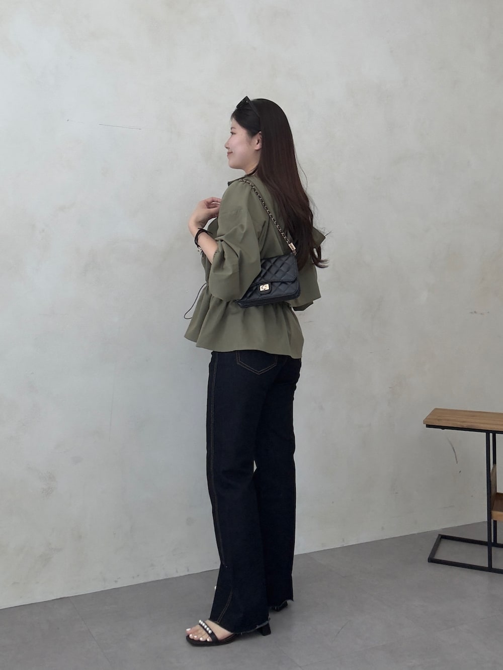 ブラック系のトートバッグ、ブルー系のデニムパンツ、ブラック系のサンダルを着用したレディースの春コーディネートの2枚目の写真