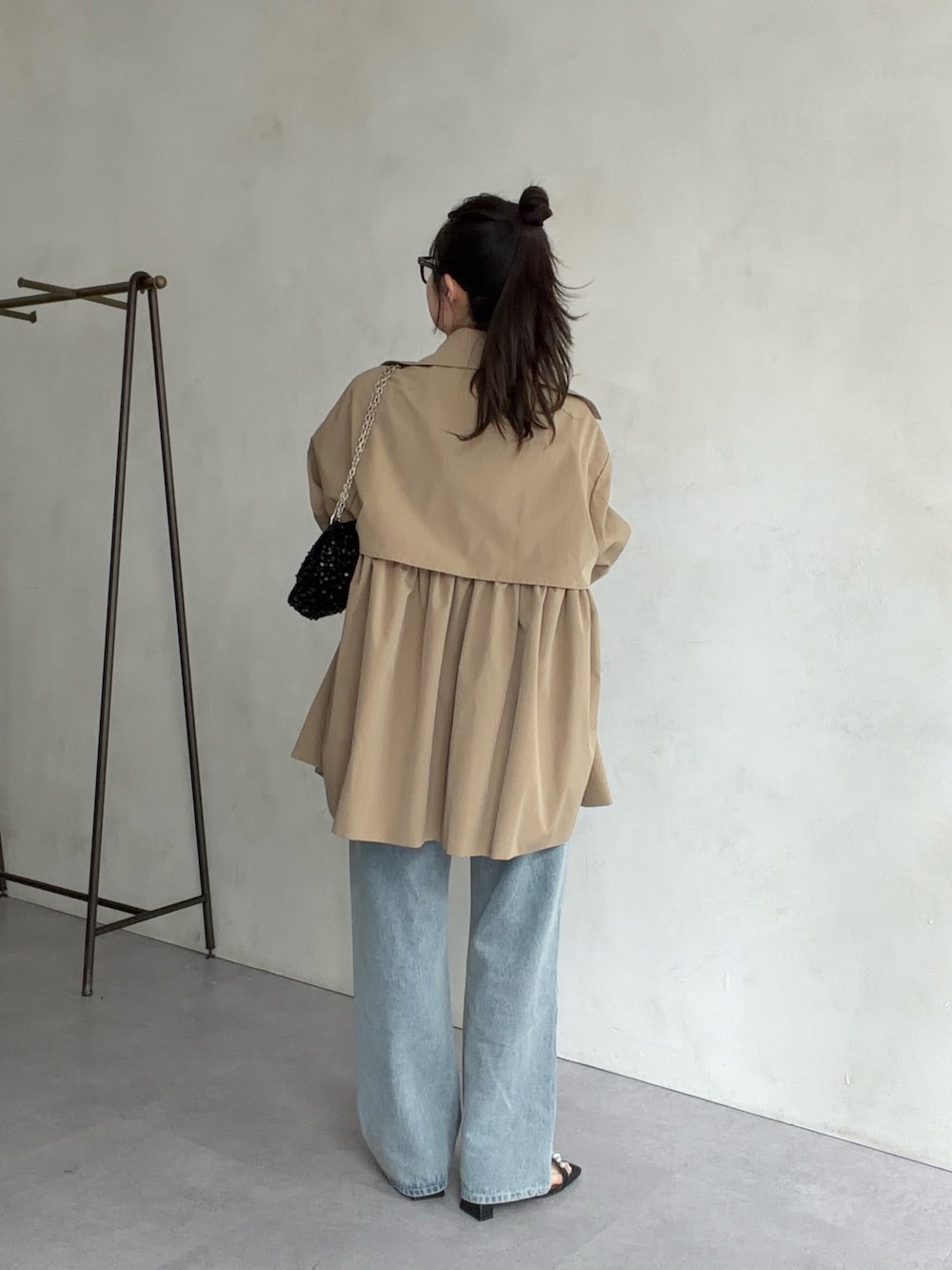 ベージュ系のトレンチコート、ブラック系のサンダル、ホワイト系のTシャツ/カットソーを着用したレディースの春コーディネートの3枚目の写真