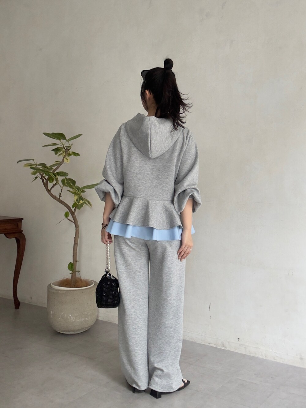 グレー系のスウェットパンツ、ブラック系のサンダル、グレー系のパーカーを着用したレディースの春コーディネートの3枚目の写真