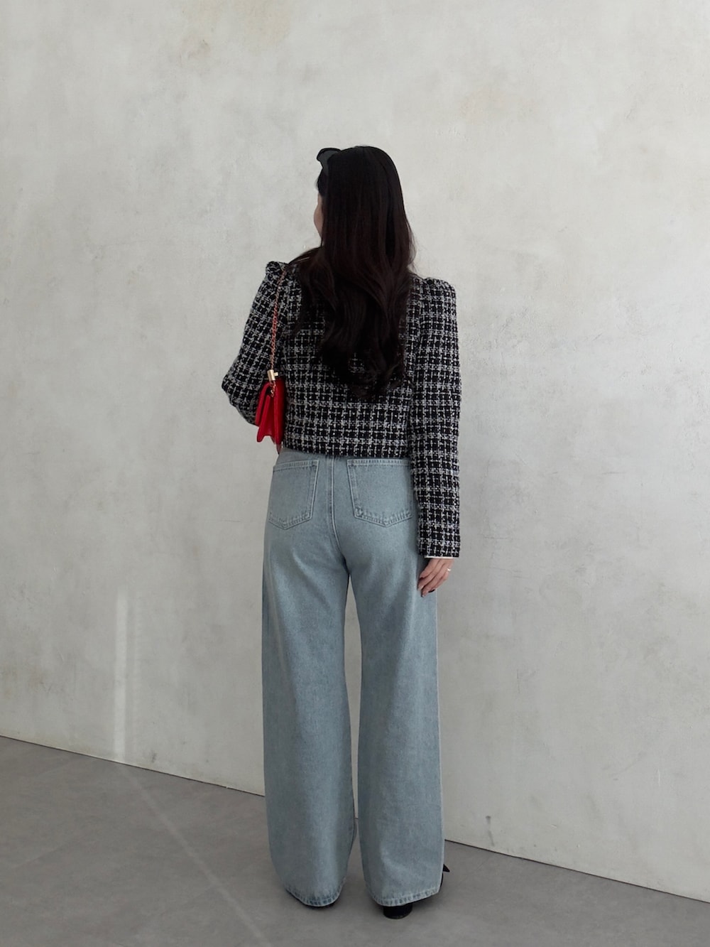 ブラック系のその他アウター、レッド系のトートバッグ、ブラック系のベストを着用したレディースの冬コーディネートの3枚目の写真