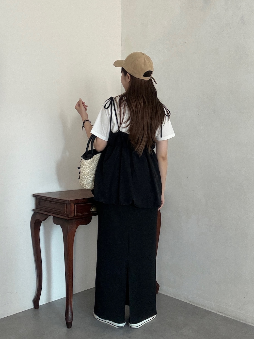 ホワイト系のTシャツ/カットソー、ブラック系のかごバッグ、ブラック系のスカートを着用したレディースの夏コーディネートの2枚目の写真