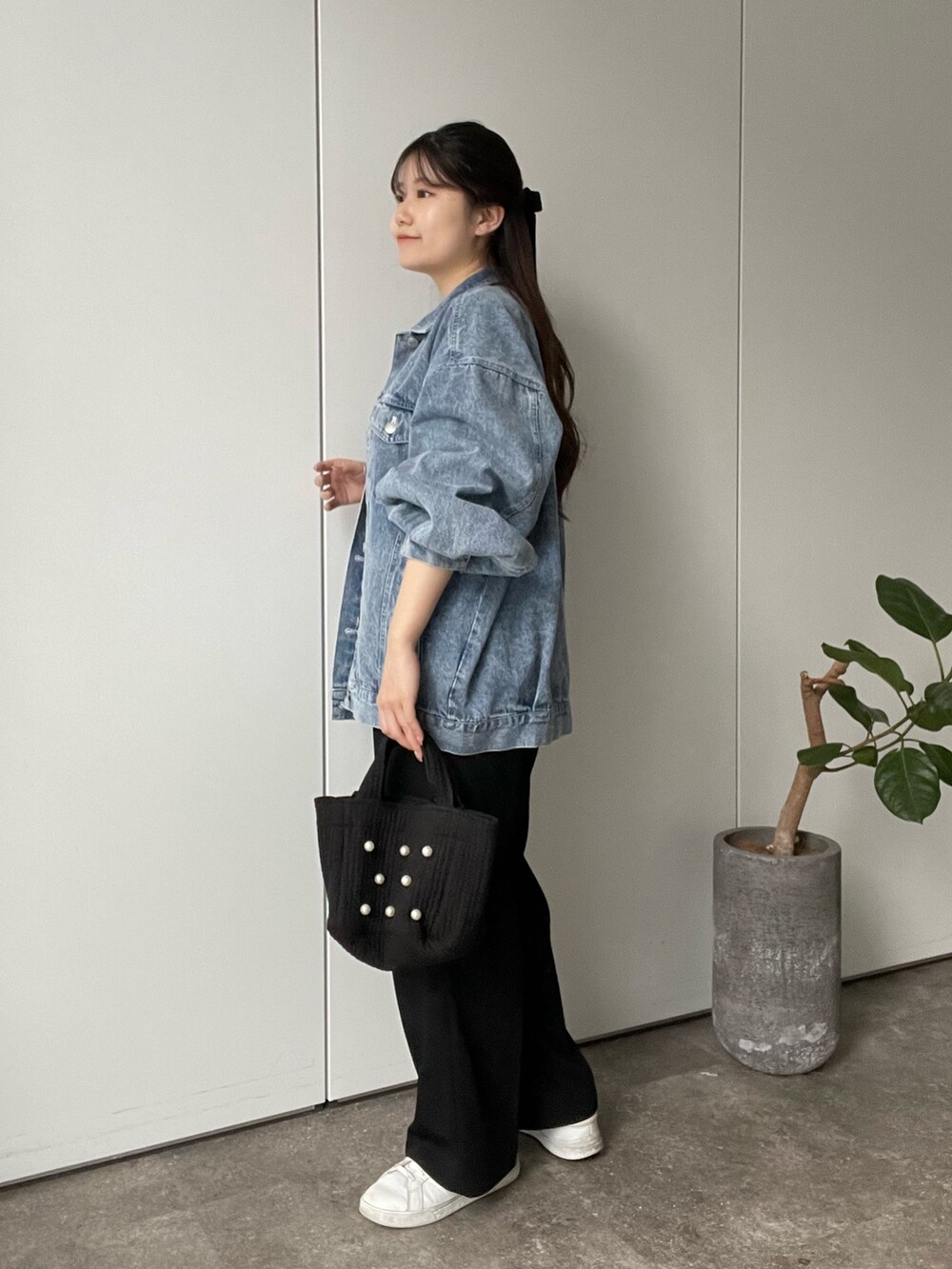 ブラック系のTシャツ/カットソー、ブルー系のデニムジャケット、ブラック系のトートバッグを着用したレディースの冬コーディネートの2枚目の写真