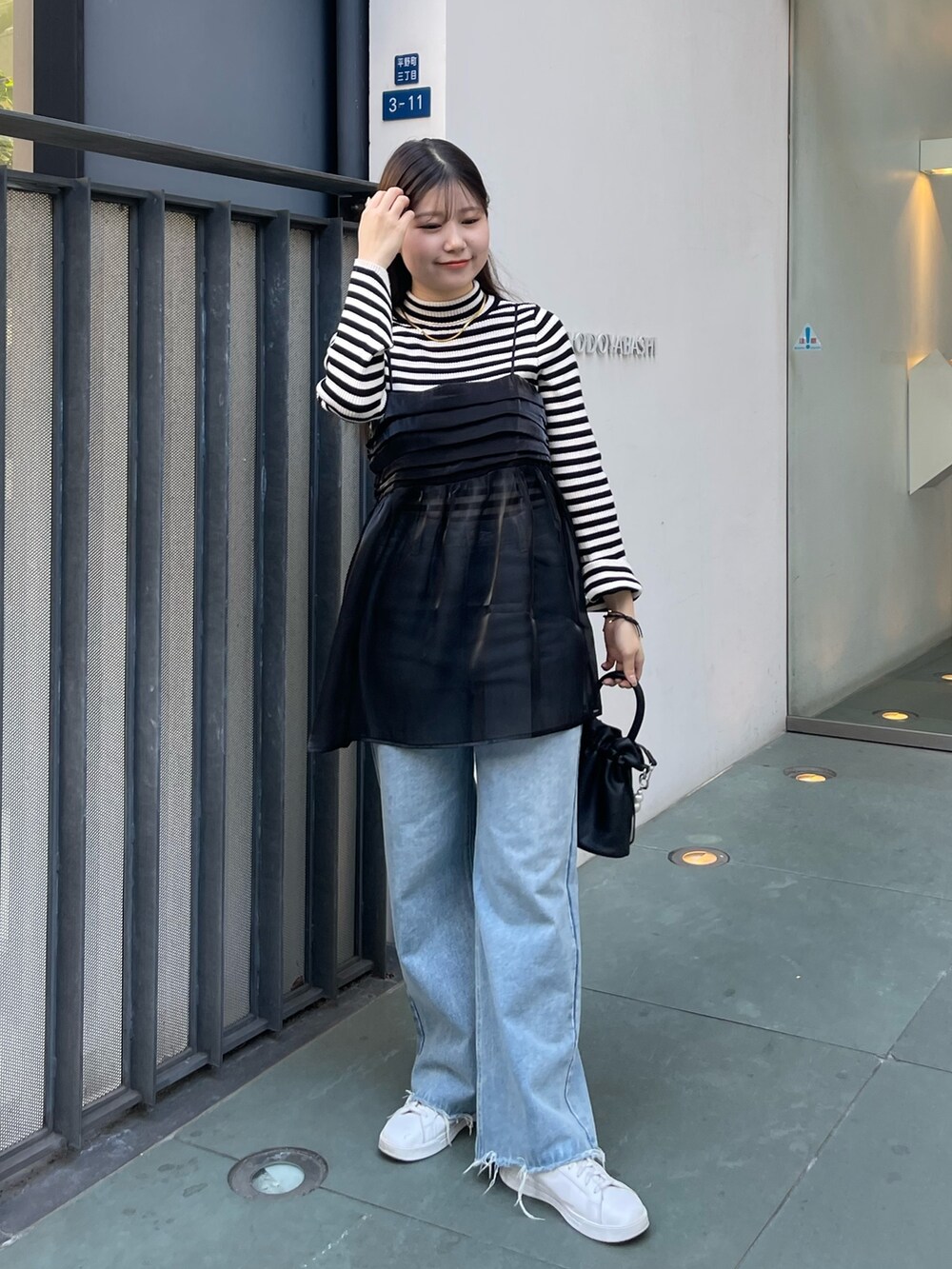 ホワイト系のニット/セーター、ブラック系のショルダーバッグ、ブラック系のキャミソールを着用したレディースの冬コーディネートの5枚目の写真