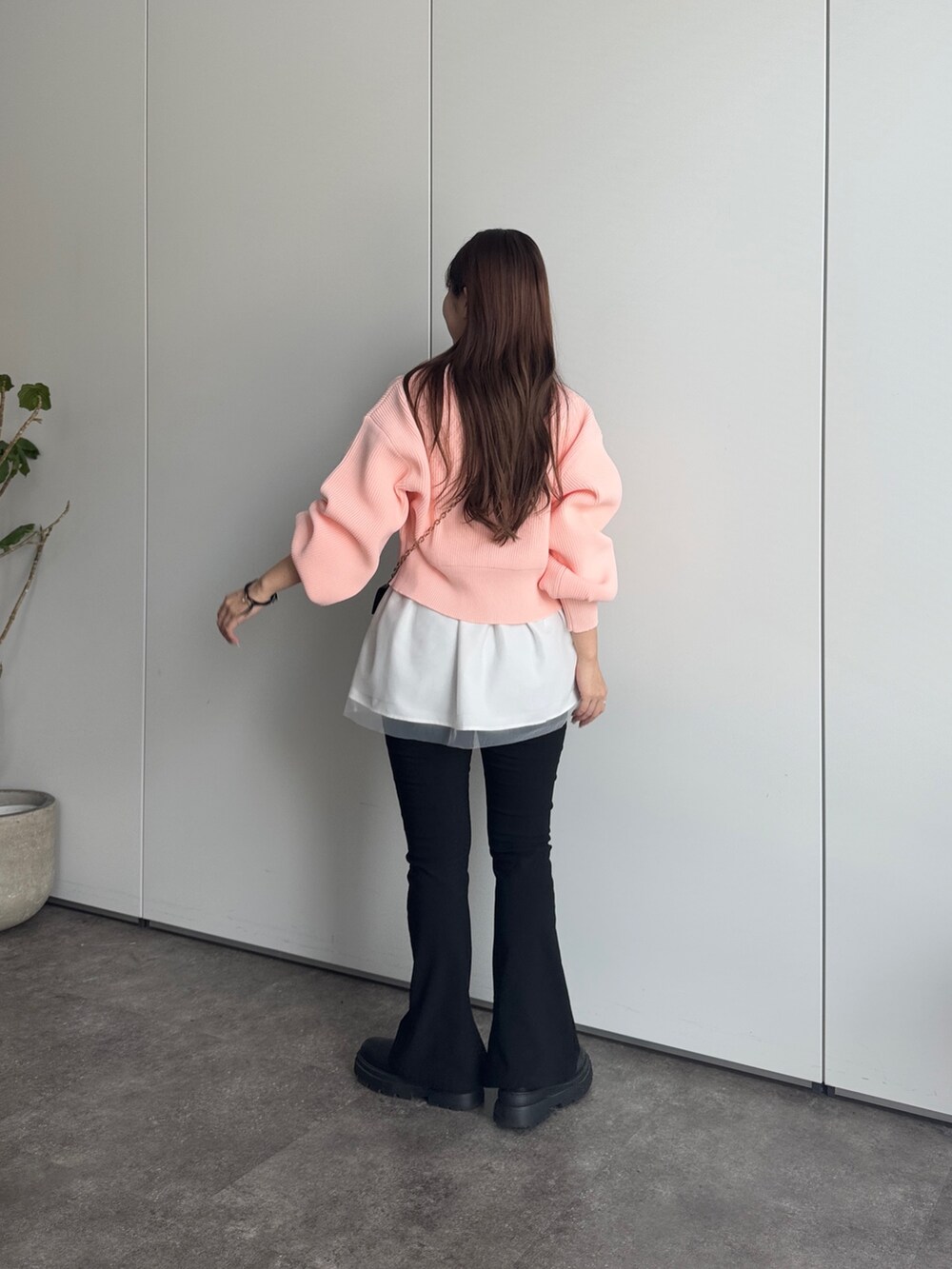 ブラック系のショルダーバッグ、ブラック系のその他パンツ、ピンク系のカーディガン/ボレロを着用したレディースの冬コーディネートの3枚目の写真