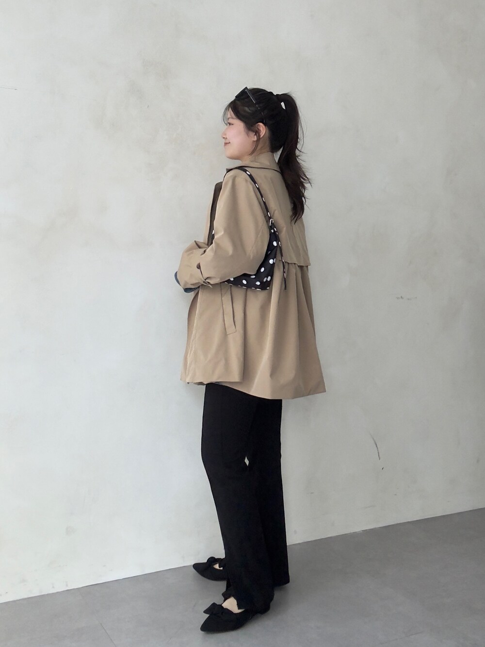 ベージュ系のトレンチコート、ブルー系のシャツ/ブラウス、ブラック系のその他パンツを着用したレディースの春コーディネートの2枚目の写真