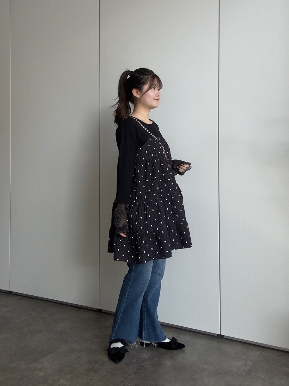 ブラック系のTシャツ/カットソー、ブラック系のキャミソール、ブルー系のデニムパンツを着用したレディースの春コーディネートの2枚目の写真