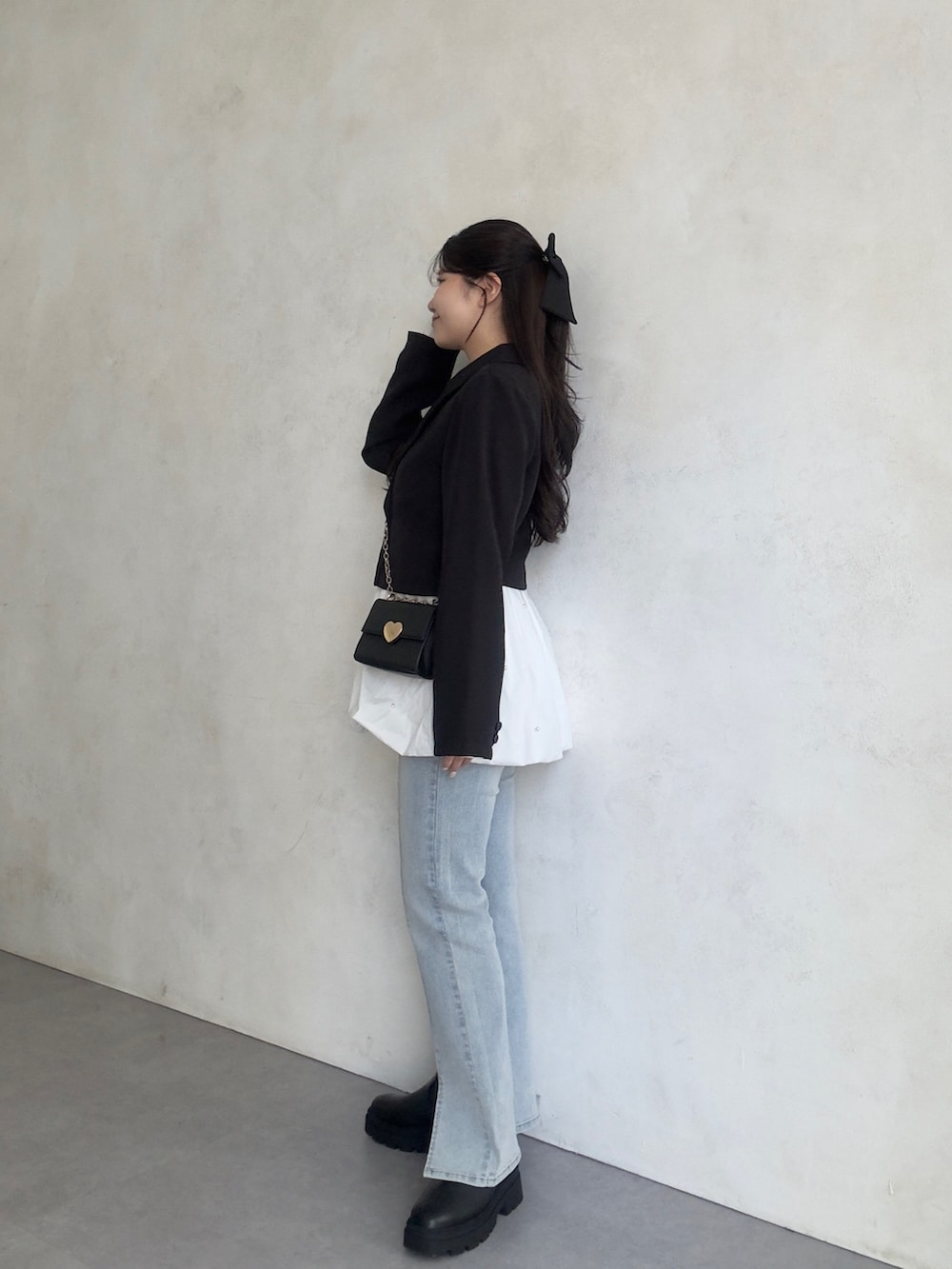 ブルー系のデニムパンツ、ブラック系のブーツ、ブラック系のテーラードジャケットを着用したレディースの秋コーディネートの2枚目の写真