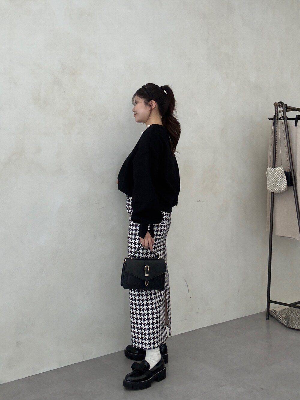 ブラック系のローファー、ブラック系のTシャツ/カットソー、ブラック系のスカートを着用したレディースの秋コーディネートの2枚目の写真