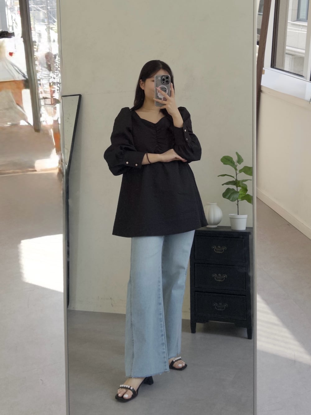 ブルー系のデニムパンツ、ブラック系のサンダル、ブラック系のシャツ/ブラウスを着用したレディースの春コーディネートの2枚目の写真