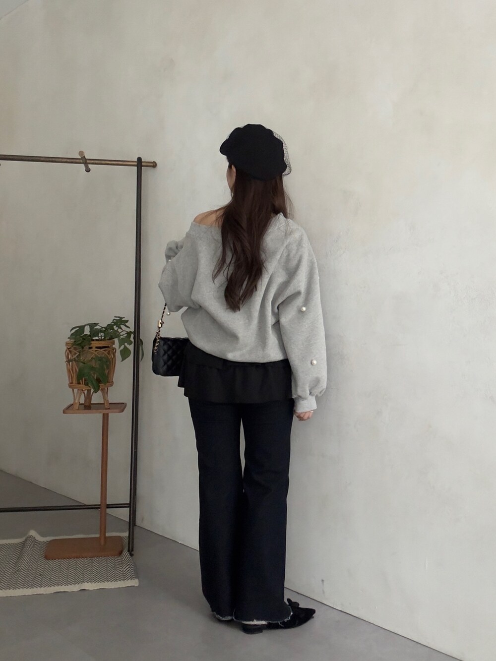 グレー系のTシャツ/カットソー、ブラック系のスカート、ブルー系のデニムパンツを着用したレディースの秋コーディネートの3枚目の写真