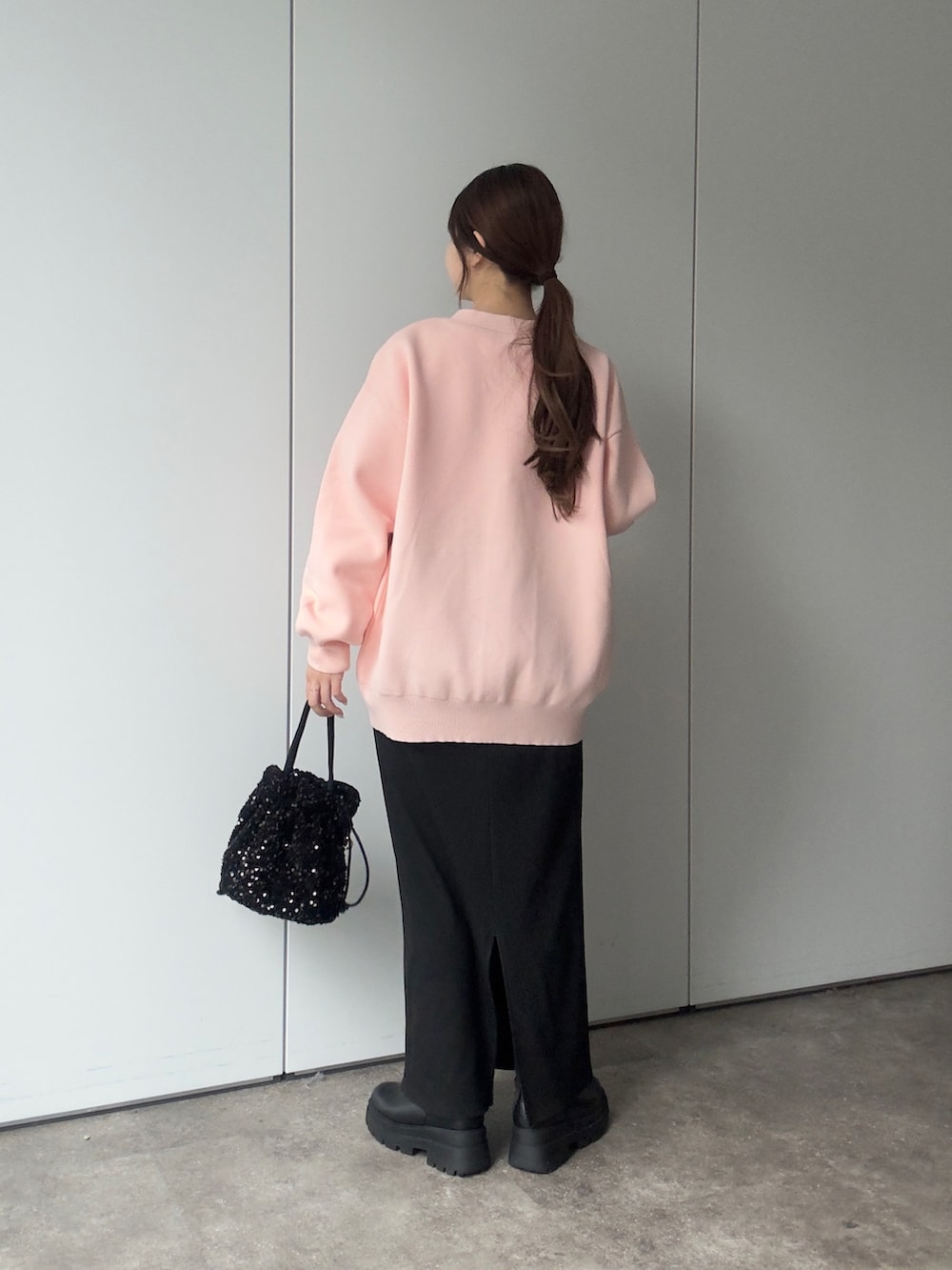 ピンク系のカーディガン/ボレロ、ホワイト系のTシャツ/カットソー、ブラック系のショルダーバッグを着用したレディースの冬コーディネートの3枚目の写真