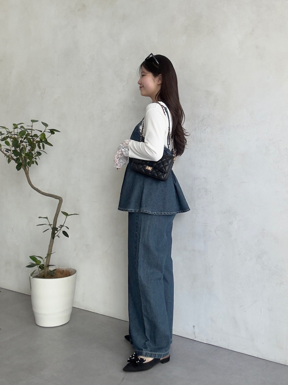 ブラック系のトートバッグ、ブルー系のサロペット/オーバーオール、ホワイト系のTシャツ/カットソーを着用したレディースの春コーディネートの2枚目の写真