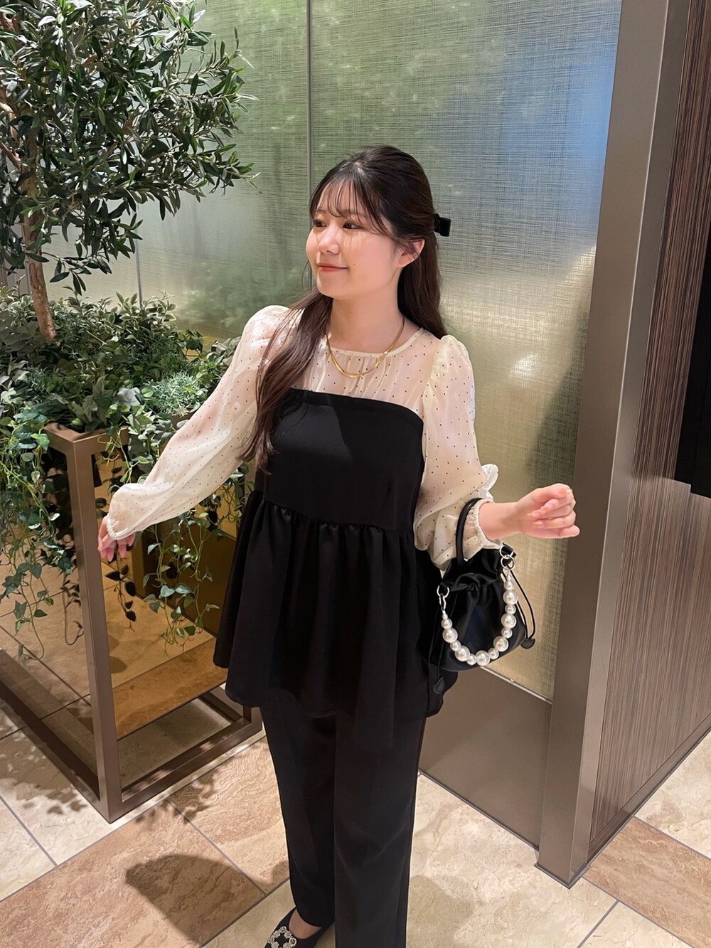 ホワイト系のシャツ/ブラウス、ブラック系のスラックス、ブラック系のパンプスを着用したレディースの冬コーディネートの2枚目の写真