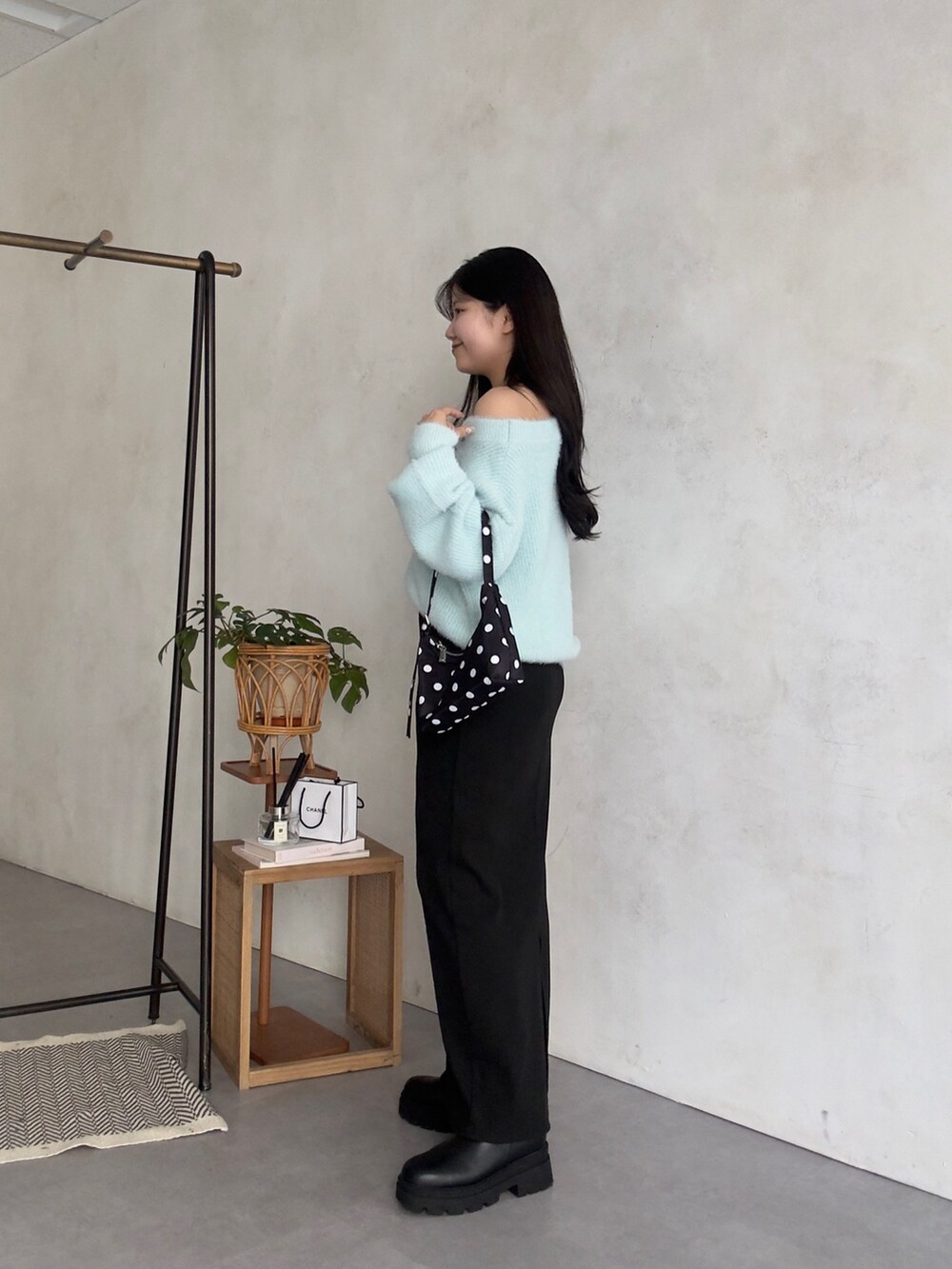 ブラック系のスカート、ブラック系のブーツを着用したレディースの冬コーディネートの2枚目の写真