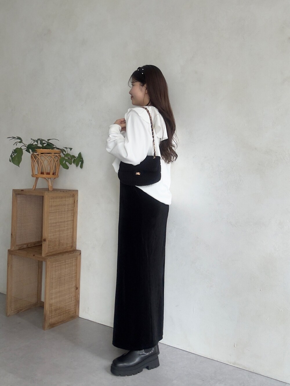 ブラック系のショルダーバッグ、ホワイト系のスウェット、ブラック系のスカートを着用したレディースの秋コーディネートの2枚目の写真