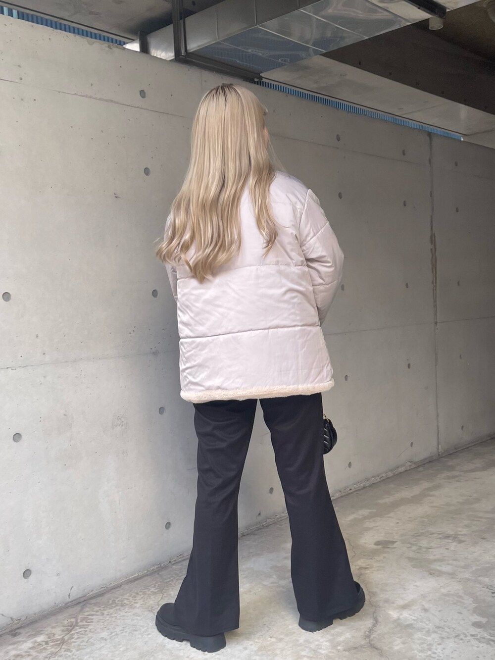 グレー系のニット/セーター、ブラック系のショルダーバッグ、ブラック系のその他パンツを着用したレディースの秋コーディネートの5枚目の写真