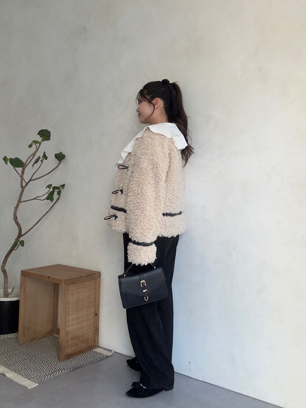 ホワイト系のスウェット、ホワイト系のブルゾン、ブラック系のスラックスを着用したレディースの秋コーディネートの2枚目の写真