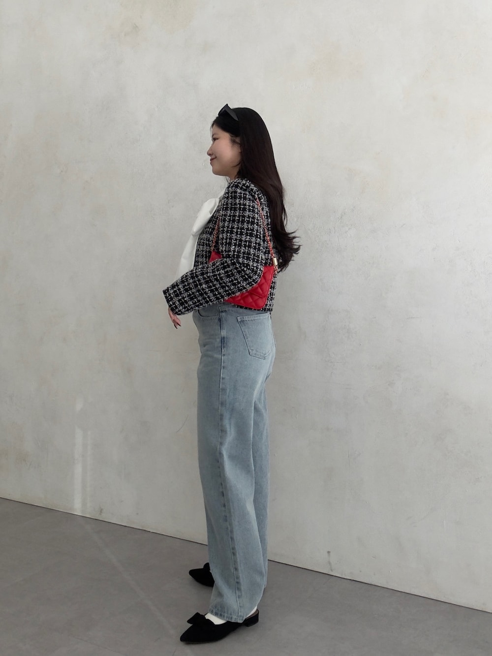 ブラック系のその他アウター、レッド系のトートバッグ、ブラック系のベストを着用したレディースの冬コーディネートの2枚目の写真