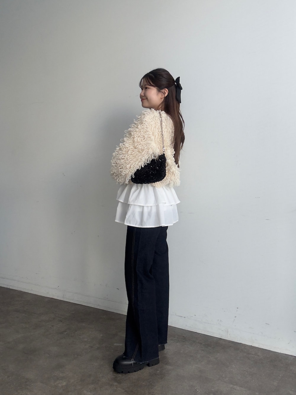 ブラック系のショルダーバッグ、ホワイト系のカーディガン/ボレロ、ホワイト系のスカートを着用したレディースの秋コーディネートの2枚目の写真