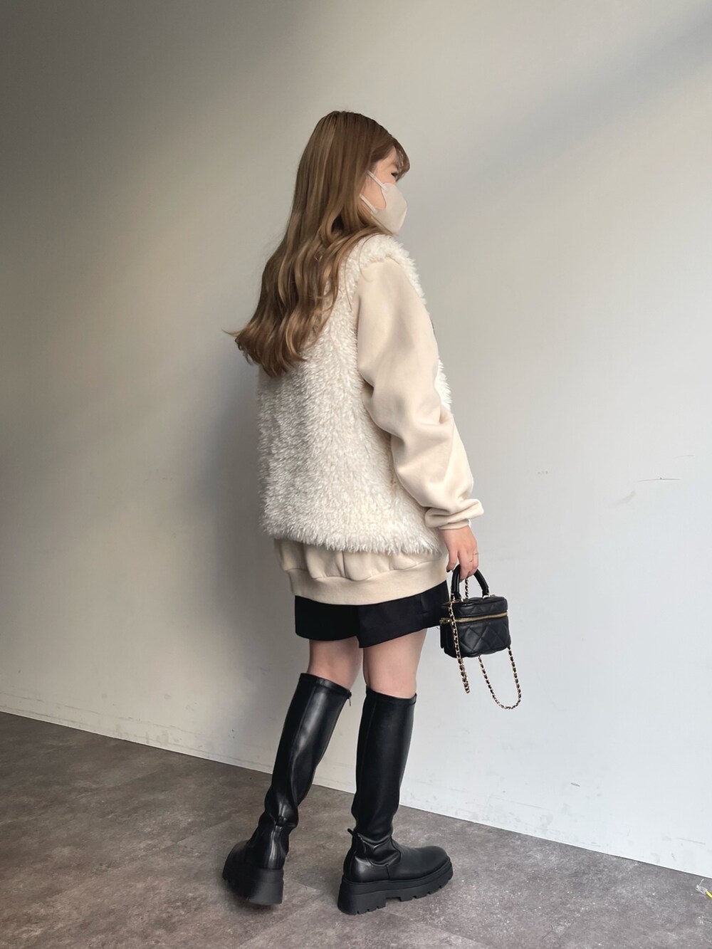 ホワイト系のスウェット、ホワイト系のベスト、ブラック系のその他パンツを着用したレディースの秋コーディネートの3枚目の写真