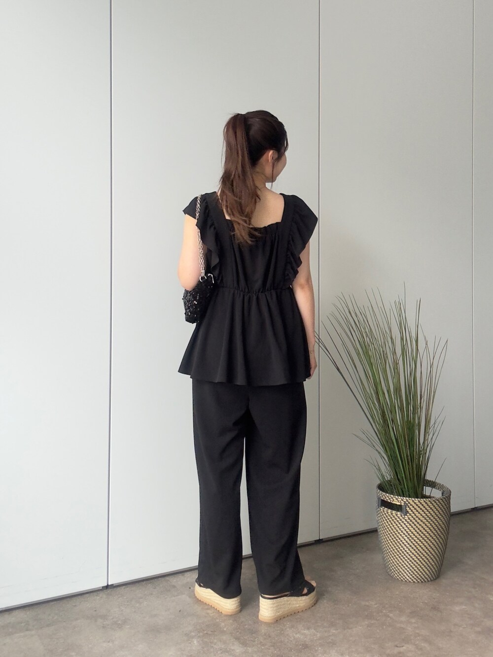 ブラック系のショルダーバッグ、ブラック系のサンダル、ブラック系のつなぎ/オールインワンを着用したレディースの夏コーディネートの3枚目の写真