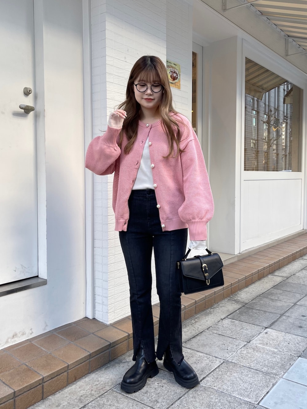 ピンク系のカーディガン/ボレロ、ホワイト系のTシャツ/カットソー、ブラック系のブーツを着用したレディースの冬コーディネートの3枚目の写真