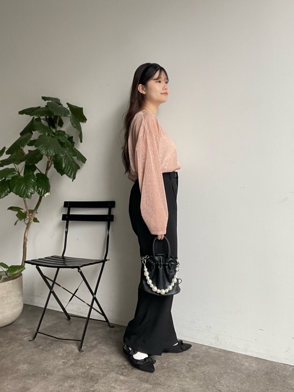 ピンク系のTシャツ/カットソー、ブラック系のスラックス、ブラック系のパンプスを着用したレディースの冬コーディネートの2枚目の写真