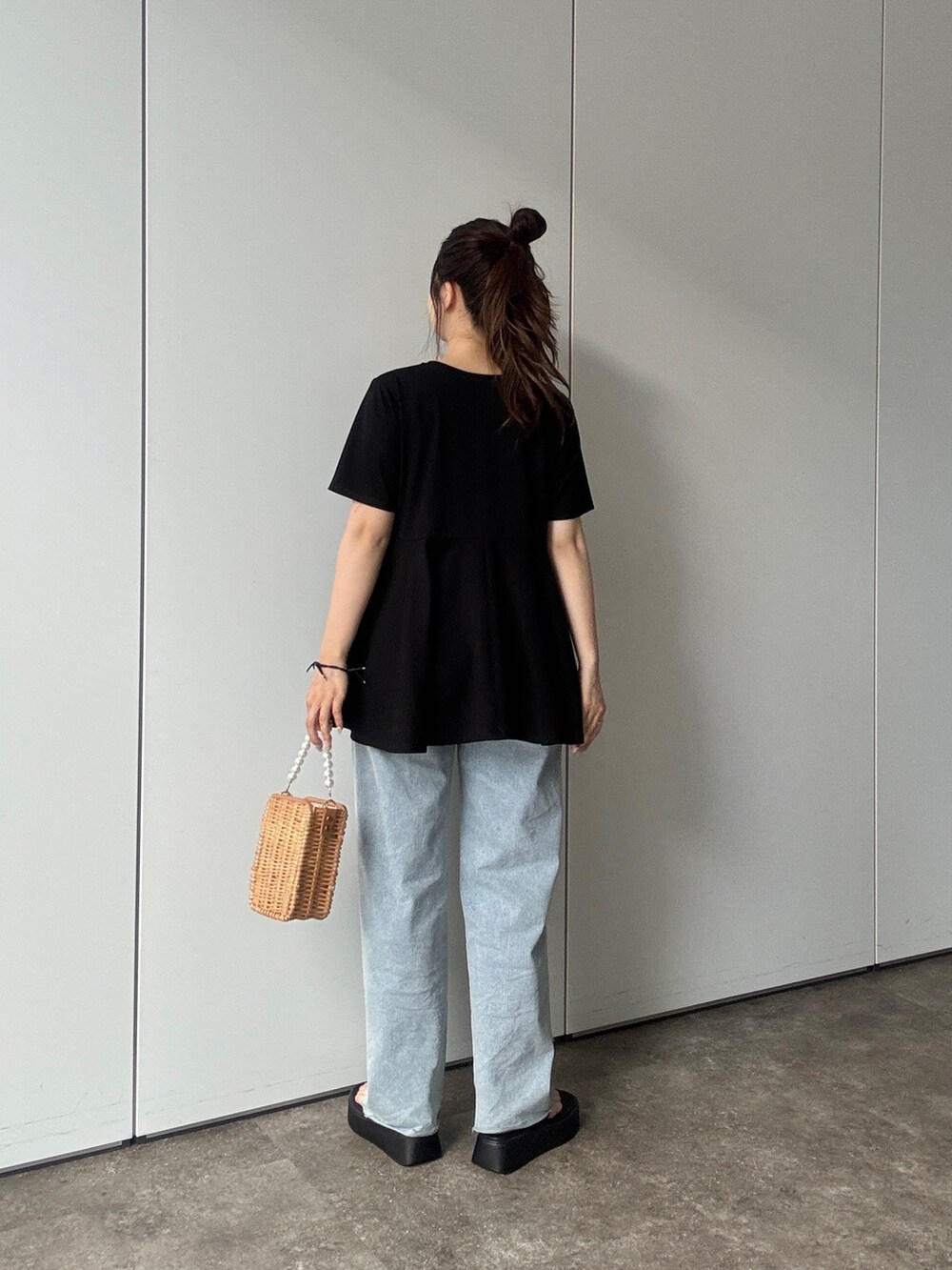 ベージュ系のショルダーバッグ、ブルー系のデニムパンツ、ブラック系のサンダルを着用したレディースの春コーディネートの3枚目の写真