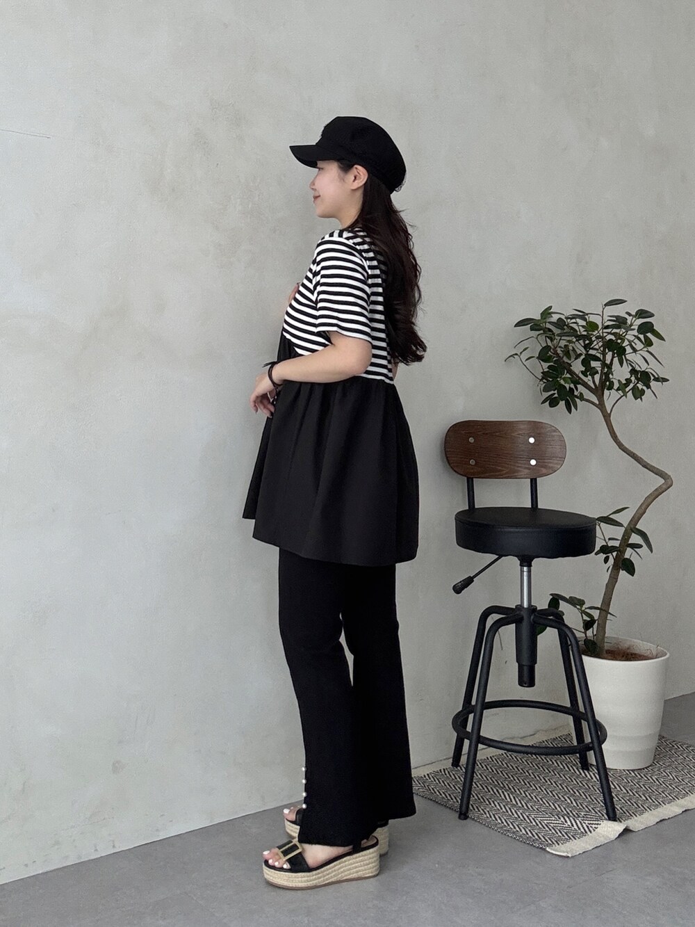 ブラック系のサンダル、ブラック系のその他パンツ、ベージュ系のかごバッグを着用したレディースの春コーディネートの2枚目の写真