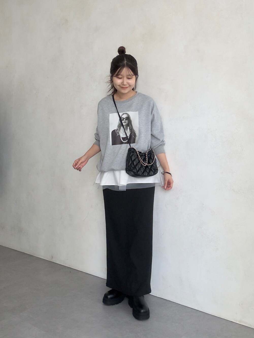 ブラック系のスカート、ブラック系のブーツ、ホワイト系のキャミソールを着用したレディースの夏コーディネートの2枚目の写真