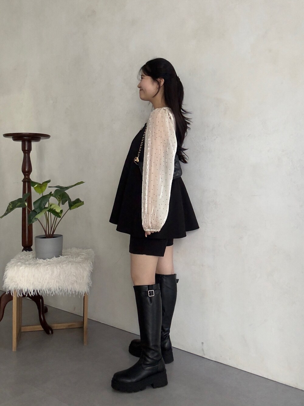 ブラック系のその他パンツ、ブラック系のブーツ、ホワイト系のシャツ/ブラウスを着用したレディースの冬コーディネートの2枚目の写真