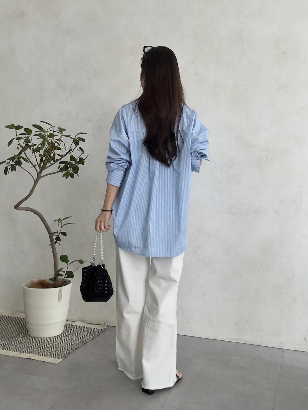 ホワイト系のその他パンツ、ブラック系のサンダル、ブルー系のシャツ/ブラウスを着用したレディースの春コーディネートの3枚目の写真