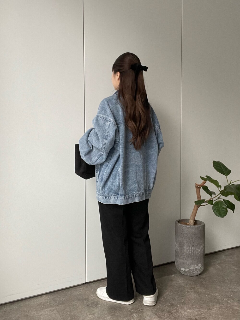 ブラック系のTシャツ/カットソー、ブルー系のデニムジャケット、ブラック系のトートバッグを着用したレディースの冬コーディネートの3枚目の写真